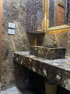 a stone bathroom with a sink and a mirror at Luxury family apartment in Cairo