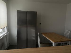 a kitchen with a stainless steel refrigerator and a wooden table at BG Homes in Peterborough