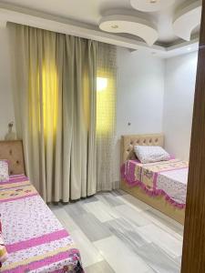 a bedroom with two beds and a curtain at Luxury family apartment in Cairo