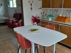 kuchnia z białym stołem i czerwonymi krzesłami w obiekcie Gîte loft au bord de la Meuse avec jardin, terrasses et activités variées à Vilosnes-Haraumont - FR-1-585-81 w mieście Vilosnes-sur-Meuse +5 zdjęć