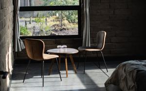 two chairs and a table in front of a window at Naakary Home in San Miguel de Allende