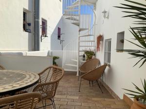 un patio con una mesa y sillas y una escalera en Atico Atlantico con Aparcamiento privado, en Vejer de la Frontera