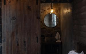 a bathroom with a mirror and a wooden wall at Naakary Home in San Miguel de Allende