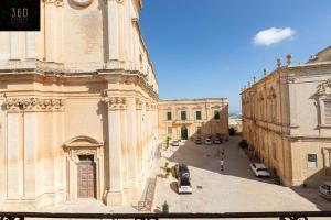 - une vue sur un bâtiment avec des voitures garées dans une rue dans l'établissement Palazzo EL Cattedrale in historic MDINA by 360 Estates, à Mdina