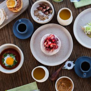 a table with plates of food and cups of coffee at Naakary Home in San Miguel de Allende +3 photos