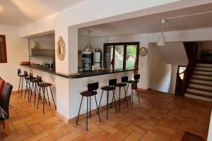 uma cozinha com um bar com bancos num quarto em La Bergerie La Belle Epoque, piscine et plage em Saint-Florent