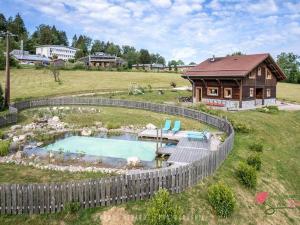 a small pool in a yard next to a house at Chalet cosy avec sauna, piscine bio, proche lac et ski à Gérardmer - FR-1-589-408 in Gérardmer