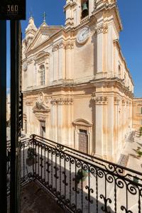 un edificio con una torre de reloj encima en Palazzo EL Cattedrale in historic MDINA by 360 Estates, en Mdina