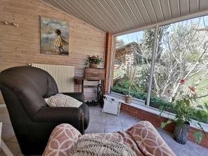 Saint-Just-près-BrioudeにあるGîte paisible rénové à St Just, terrasse privée, randonnées, proche Puy en Velay - FR-1-582-343のリビングルーム(革張りの椅子、大きな窓付)
