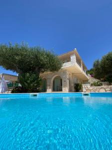 a large swimming pool in front of a house at Federico Villa in Khalikerí