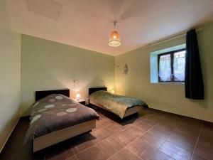 um quarto com 2 camas e uma janela em Gîte Cistrières, 3 pièces, 4 personnes - FR-1-582-345 