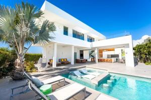 a villa with a swimming pool and a house at Oceanside 3 Bedroom Luxury Villa with Private Pool, 500ft from Long Bay Beach -V2 in Providenciales