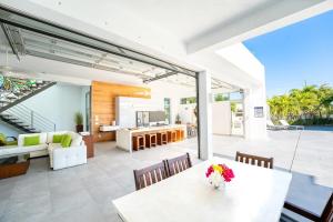 Oceanside 3 Bedroom Luxury Villa with Private Pool, 500ft from Long Bay Beach -V2 في بروفيدنسياليس: مطبخ مفتوح وغرفة معيشة مع طاولة وكراسي