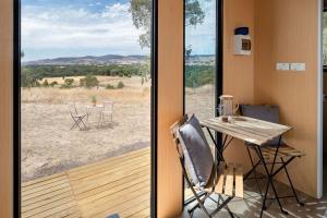 - une table et des chaises dans une chambre avec fenêtre dans l'établissement Hill View at Euroa Glamping, à Euroa