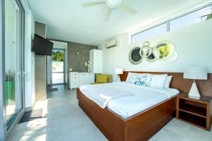 Oceanside 3 Bedroom Luxury Villa with Private Pool, 500ft from Long Bay Beach -V2 في بروفيدنسياليس: غرفة نوم بسرير كبير وتلفزيون