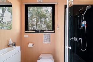 La salle de bains est pourvue d'une douche, de toilettes et d'une fenêtre. dans l'établissement Hill View at Euroa Glamping, à Euroa
