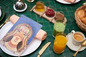 einen Tisch mit Teller mit Lebensmitteln und Gläsern Orangensaft in der Unterkunft IZZA Marrakech in Marrakesch