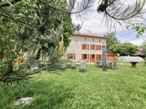 une maison avec une cour dotée de chaises et d'un parasol dans l'établissement Gîte Craponne-sur-Arzon, 6 pièces, 10 personnes - FR-1-582-346, à Craponne-sur-Arzon