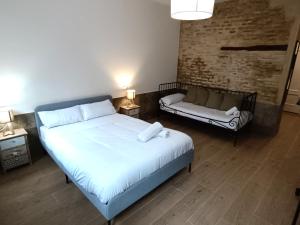 1 dormitorio con cama blanca y sofá en Almona Puente de Barcas - Kainga Homes, en Sevilla