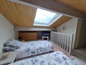 ein Schlafzimmer mit einem Bett und einem Dachfenster in der Unterkunft Gîte Bar-le-Duc, 2 pièces, 4 personnes - FR-1-585-84 in Bar-le-Duc