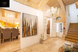 a dining room with a painting on the wall at Palazzo EL Cattedrale in historic MDINA by 360 Estates in Mdina