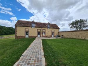 un gran edificio de ladrillo con un patio de césped en Gîte Chevannes, 4 pièces, 6 personnes - FR-1-590-244, en Chevannes