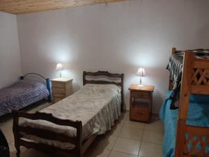 een slaapkamer met 2 bedden en 2 nachtkastjes bij Cabaña Villa del Dique in Villa del Dique
