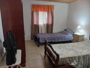 a room with two beds and a fan in it at Cabaña Villa del Dique in Villa del Dique