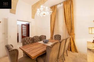 comedor con mesa de madera y sillas en Palazzo EL Cattedrale in historic MDINA by 360 Estates, en Mdina