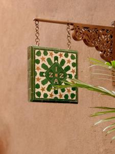 a green and white tile hanging on a wall at IZZA Marrakech in Marrakech