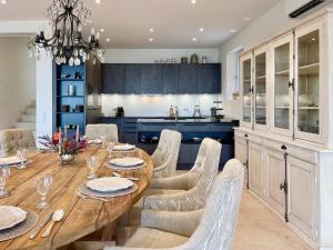 Una cocina y un comedor con mesa y sillas de madera. en Mas La Rose Sauvage - magnificent Luberon views, en Murs