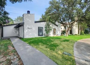 a white house with a driveway at Cozy 4 bedroom home with hot tub galleria location in Dallas