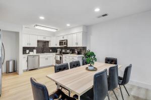 a kitchen and dining room with a wooden table and chairs at Cozy 4 bedroom home with hot tub galleria location in Dallas