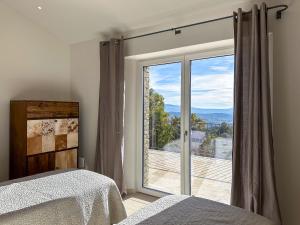 - une chambre avec une grande porte en verre offrant une vue dans l'établissement Mas La Rose Sauvage - magnificent Luberon views, à Murs