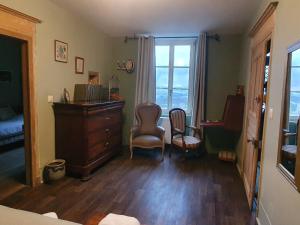 a bedroom with a dresser and a desk and chairs at Escapade de charme près de Verdun : cocon pour 2 personnes avec cuisine équipée et balades à proximité - FR-1-585-85 in Souilly +2 photos