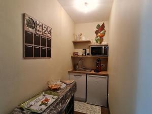 a small kitchen with a sink and a microwave at Escapade de charme près de Verdun : cocon pour 2 personnes avec cuisine équipée et balades à proximité - FR-1-585-85 in Souilly