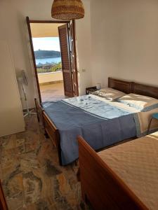 um quarto com uma cama e uma porta para uma varanda em Villa Greco em Cirella