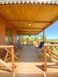 a wooden deck with chairs and tables on it at Cabaña La Paz in San Andrés de Giles +20 photos