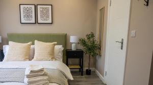 a bedroom with a bed and a table with a plant at Private double bedroom with bathroom and amenities in Harrow