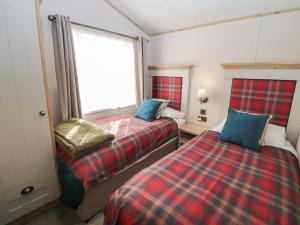 a bedroom with two beds and a window at Gressingham 7 in Carnforth