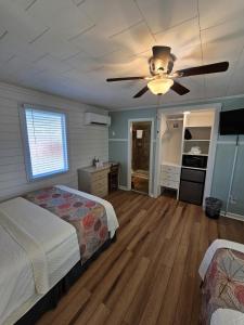 een slaapkamer met een bed en een plafondventilator bij Island Motel OBX in Manteo