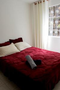 uma cama num quarto com um cobertor vermelho e uma janela em Apartamento cerca centro bogota em Bogotá