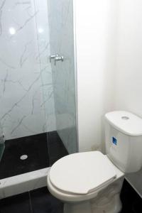 y baño con aseo blanco y ducha. en Apartamento cerca centro bogota, en Bogotá