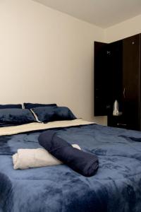 Una cama con una manta azul encima. en Apartamento cerca centro bogota, en Bogotá