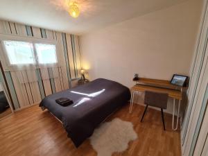 a bedroom with a bed and a desk and a table at Gîte tout confort avec jacuzzi, proche Loire et forêt d'Orléans, idéal pour séjours nature et détente - FR-1-590-253 in Ouzouer-sur-Loire