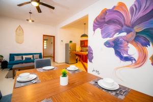 una sala de estar con una mesa y una pintura en la pared en Hotel Ak'Na Holbox en Holbox Island