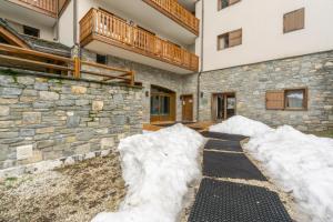 a stone house with snow on the ground at Appartement B56 - Eco Le Ruitor in Sainte-Foy-Tarentaise