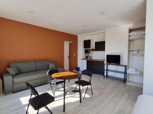 sala de estar con sofá, mesa y sillas en Appartement Lacroix-sur-Meuse, 2 pièces, 2 personnes - FR-1-585-92, en Lacroix-sur-Meuse