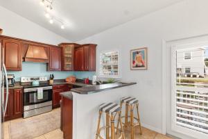 a kitchen with wooden cabinets and bar stools at 4BR house, 2 blocks from the beach in St. Augustine