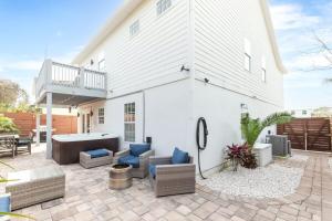 a patio with furniture and a white house at 4BR house, 2 blocks from the beach in St. Augustine